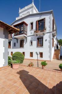 a large white building with windows and potted plants at Mas Llavaneres in Sant Andreu de Llavaneres