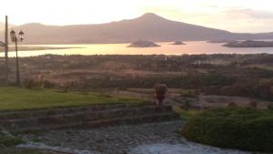 a person standing on a stone wall looking at a lake at Eco Hotel Ixhi in Pátzcuaro