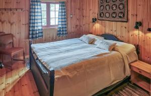 a bedroom with a large bed in a room with wooden walls at Stunning Home In Rjukan With Sauna in Rjukan +21 photos