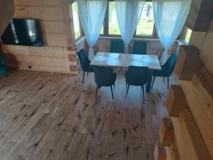 a dining room with a wooden table and chairs at Szlacheckie Domki in Kroczyce