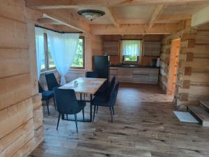 a kitchen and dining room with a wooden table and chairs at Szlacheckie Domki in Kroczyce