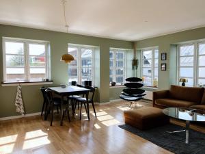 ein Wohnzimmer mit einer Couch und einem Tisch und Stühlen in der Unterkunft Experience Trshavn's Vibrant Culture in Tórshavn + 6 Fotos