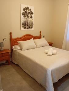 a bedroom with a large bed with white sheets at La Muralla de Gredos in Madrigal de la Vera