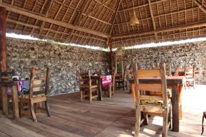 une pièce avec des tables et des chaises en bois dans un bâtiment dans l'établissement Bungalows Resort, à Mwanahaza