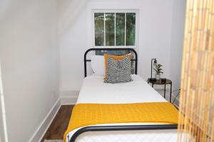 a bedroom with a bed with a yellow blanket and a window at Modern & Spacious Home Near Downtown Atlanta in Atlanta