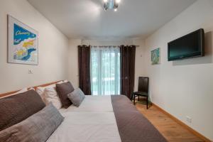 a bedroom with a bed and a flat screen tv at Lodge 1, Hot Tub And Bbq in Champéry