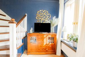 a room with a tv on a dresser with a staircase at Wohnen im Carl Maria von Weber Geburtshaus in Eutin