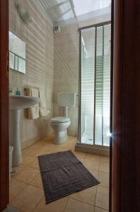 a bathroom with a toilet and a sink and a mirror at Joanne B&B in Canicattini Bagni