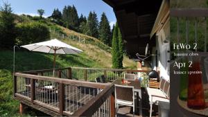 eine Veranda mit einem Tisch und einem Sonnenschirm in der Unterkunft Ferienhaus Auschmiede in Hollersbach im Pinzgau