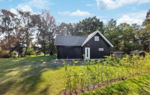 a small black house on a grass field at Svarta Huset in Munka-Ljungby