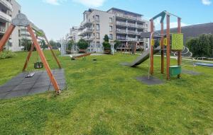un parque con parque infantil con tobogán y columpios en Gorgeous Apartment In Sianozety, en Sianożęty