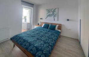 Un dormitorio con una cama con un edredón azul. en Gorgeous Apartment In Sianozety, en Sianożęty