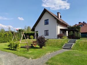 a white house with a swing and a playground at Słoneczne Wzgórze in Jeżów Sudecki