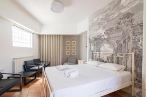 アテネにあるVilla Anna under Acropolisの白いベッドと壁画が備わるベッドルーム1室が備わります。