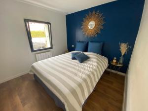 a bedroom with a bed with a blue wall at La Romerel/Maison piscine/400m plage et commerces! in Châtelaillon-Plage +3 photos