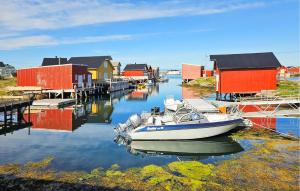 a boat is docked in the water next to houses at 3 Bedroom Amazing Home In Sula in Sula