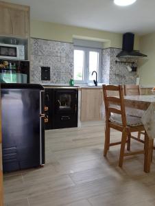 a kitchen with a black refrigerator and a table at Casa Marcelino in Reinante