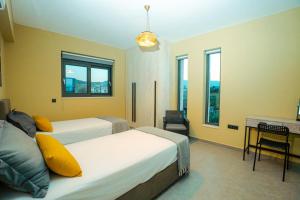 Un dormitorio con dos camas y un escritorio y ventanas. en Seaside Villa Volter, en Kypseli 46 fotos más
