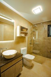 Un baño con inodoro, lavabo y ducha. en Seaside Villa Volter, en Kypseli