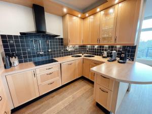 een keuken met houten kasten en een aanrechtblad bij Hello Zeeland - Appartement Loverendale 31 in Domburg