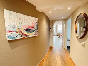 een hal met een schilderij aan de muur en een spiegel bij Hello Zeeland - Appartement Loverendale 31 in Domburg