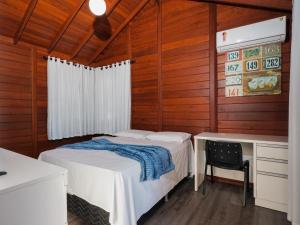 a bedroom with two beds and a desk in it at Casa c/ piscina privativa a 150m da praia PU9263 in Itajubá +30 photos