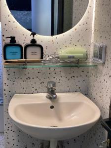 Un lavabo con tres botellas en un estante encima. en Laca Homestay HangDa, en Hanói