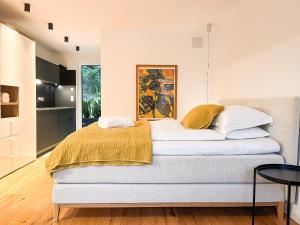 a bedroom with a bed with a yellow blanket on it at Garden Apartment Untermühle in Bressanone