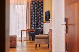 a room with a chair and a desk and a window at Hotel Hafenspeicher in Leer