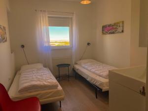 ein Zimmer mit zwei Betten und einem Fenster in der Unterkunft Hello Zeeland - Appartement Port Scaldis 19-042 in Breskens