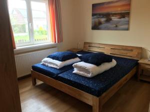 two pillows on a bed in a room with a window at Hello Zeeland - Vakantiehuis Het Heem 39 in Breskens