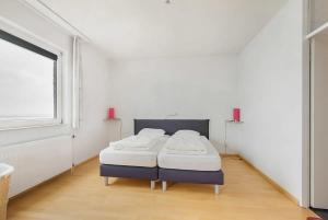 a bedroom with a bed in a room with a window at Hello Zeeland - Appartement Port Scaldis 13-112 in Breskens
