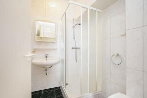 a white bathroom with a shower and a sink at Hello Zeeland - Appartement Port Scaldis 13-112 in Breskens +7 photos