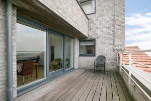 a balcony with a table and chairs on a building at Hello Zeeland - Appartement Port Scaldis 13-112 in Breskens