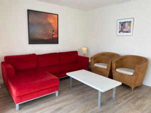 a living room with a red couch and chairs at Hello Zeeland - Vakantiehuis Zwin 182 in Breskens