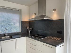 a kitchen with a sink and a stove top oven at Hello Zeeland - Vakantiehuis Zwin 182 in Breskens