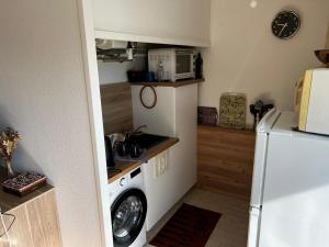 eine Küche mit Waschmaschine und Mikrowelle in der Unterkunft Appartement proche Bordeaux et Aéroport in Mérignac