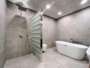 a bathroom with a tub and a shower and a toilet at Penthouse by Krambatangi in Øravík +33 photos