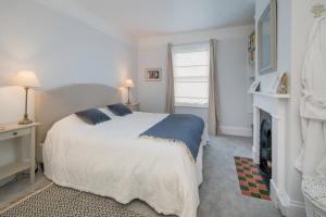 a white bedroom with a bed and a fireplace at Shellharbour in Seaview