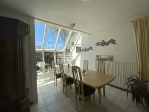 a dining room with a table and chairs and a window at Hello Zeeland - Vakantiehuis Zwin 092 in Breskens