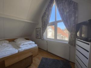 a bedroom with a bed and a large window at Hello Zeeland - Vakantiehuis Zwin 092 in Breskens