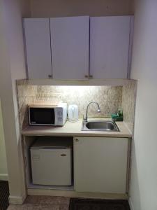 a small kitchen with a sink and a microwave at Kuala Lumpur Grand service suite at Times Square in Kuala Lumpur