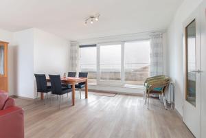 a living room with a dining room table and chairs at Hello Zeeland - Appartement Port Scaldis 11-112 in Breskens