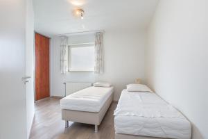 a bedroom with two beds and a window at Hello Zeeland - Appartement Port Scaldis 11-112 in Breskens