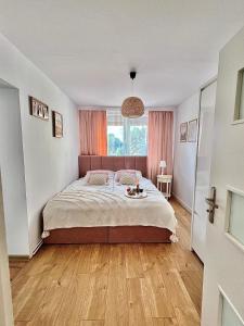 a bedroom with a large bed with a wooden floor at Agroturystyka Parlińskie Wody I in Parlino