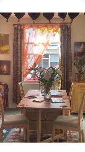 a dining room table with a vase of flowers on it at Glastonbury 2-Bed House Sleeps 6 & Pet Friendly in Glastonbury +7 photos