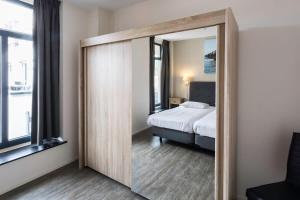 ein Spiegel in einem Zimmer mit einem Bett und einem Schlafzimmer in der Unterkunft Hello Zeeland - Appartement Wijngaerde Residence 19 in Domburg + 7 Fotos
