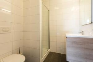 a bathroom with a toilet and a shower and a sink at Hello Zeeland - Appartement Wijngaerde Residence 19 in Domburg +8 photos