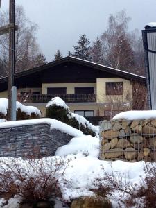 Una casa con nieve en el suelo delante de ella. en Appartements ISOLA Bad Kleinkirchheim, en Untertschern