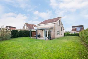 a house with a lawn in front of it at Hello Zeeland - Vakantiehuis Schelde 194 in Breskens